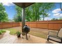 Well-maintained backyard with stone patio, grill, and privacy fence at 10731 Bossier Dr, Alpharetta, GA 30022