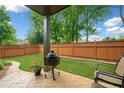 A well-maintained backyard with a patio, grill, and lush green lawn, perfect for outdoor entertaining at 10731 Bossier Dr, Johns Creek, GA 30022