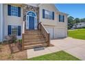 Home featuring a cozy front entrance, stone details, and an attached two-car garage at 3290 Spincaster Way, Loganville, GA 30052