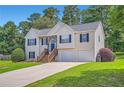 Traditional home with a two-car garage, front lawn, and blue shutters under a bright sky at 3290 Spincaster Way, Loganville, GA 30052