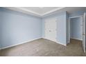 This carpeted bedroom features a trey ceiling, blue walls, and a closet with double doors at 5380 Rock Place Drive, Stone Mountain, GA 30087