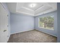 This carpeted bedroom features a trey ceiling, blue walls, and a large window for natural light at 5380 Rock Place Drive, Stone Mountain, GA 30087