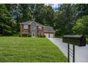 Two-story home with a brick and siding exterior, a two-car garage, and a large front yard at 5380 Rock Place Drive, Stone Mountain, GA 30087