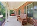 Inviting front porch with a wooden bench and swing, ideal for enjoying the outdoors at 169 Robson Trl, Mcdonough, GA 30252
