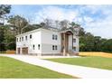 Wide angle view of a two-story home and driveway with a combination stone and light gray exterior at 2369 Mcafee Rd, Decatur, GA 30032