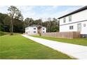 Two story home with a combination stone and light gray exterior, long driveway and green grass at 2369 Mcafee Rd, Decatur, GA 30032