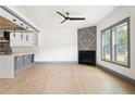 Open concept living room with hardwood floors, modern fireplace, ceiling fan and decorative lighting at 2369 Mcafee Rd, Decatur, GA 30032