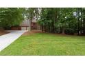 A classic two-story brick home with a spacious driveway and lush green lawn at 5190 Southlake Dr, Alpharetta, GA 30005