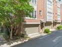 Brick townhome exterior with individual garages on a tree-lined street showing urban living at 1376 Parkview Ne Ln, Atlanta, GA 30324