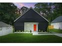 Charming exterior elevation of a modern home with black siding, a bright orange front door and a well manicured lawn at 587 Woods Nw Dr, Atlanta, GA 30318