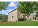 Side yard view of home with lush green grass and landscaping featuring a mature shade tree at 2755 Evan Manor Ln, Cumming, GA 30041