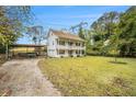 Charming two-story home featuring a welcoming porch on both levels, long driveway, and a spacious front yard with carport at 4141 Willow Ridge Rd, Douglasville, GA 30135