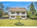 Charming two-story home featuring a welcoming porch on both levels and a spacious front yard with a young tree at 4141 Willow Ridge Rd, Douglasville, GA 30135