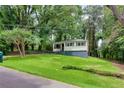 Home with a tree in the yard and a long driveway at 629 Hickory Se Trl, Mableton, GA 30126