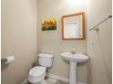 Well-lit powder room with pedestal sink, toilet, and decorative wall art at 1343 Penhurst Dr, Lawrenceville, GA 30043