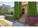 Welcoming townhome entrance with landscaped shrubs leading to the front door and exterior details at 7275 Highland Blf # 8, Atlanta, GA 30328