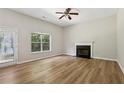 Spacious living room with hardwood floors, fireplace, a ceiling fan, and natural light at 1025 Pebble Creek Trl, Suwanee, GA 30024