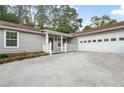 Ranch home showcasing a two-car garage, freshly painted siding, and a welcoming front porch with white railings at 1181 Mannbrook Dr, Stone Mountain, GA 30083