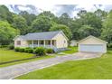 Charming one-story home with a inviting front porch, a lush lawn, and a detached two-car garage at 3100 Meadow Trl, Loganville, GA 30052