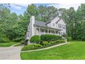 A beautifully landscaped home with a lush lawn and mature trees, featuring a charming front porch at 5609 Twin Oak Dr, Douglasville, GA 30135