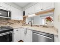 Updated kitchen featuring white cabinets, stainless steel appliances and stylish backsplash at 1800 Clairmont #428 Lk # A428, Decatur, GA 30033