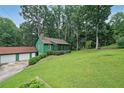 Quaint green home featuring a screened front porch, a separate two-car garage, and a well-manicured lawn at 3743 Wyntuck Nw Cir, Kennesaw, GA 30152