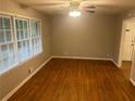 Inviting living room featuring gleaming hardwood floors and natural light from large windows at 4902 Pine Hill E Ct, Stone Mountain, GA 30088