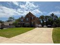Two-story home with an expansive driveway offers ample parking and features a well-maintained lawn and mature trees at 8340 Nolandwood Ln, Villa Rica, GA 30180