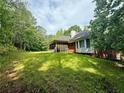 Spacious backyard featuring lush green grass, screened-in porch, and mature trees at 8872 Conners Rd, Villa Rica, GA 30180