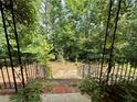 View from front porch showing steps and iron railing, nestled within lush greenery at 8872 Conners Rd, Villa Rica, GA 30180