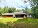 Home's rear exterior view showing a screened porch and a large, grassy yard at 8872 Conners Rd, Villa Rica, GA 30180