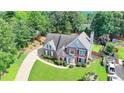 An aerial view of a brick home featuring a long driveway and private backyard at 189 Azalea Chase Dr, Suwanee, GA 30024