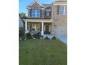 Charming brick home with covered porch, neat landscaping, and a well-maintained lawn at 3675 Brookhollow Dr, Douglasville, GA 30135