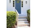 Welcoming entryway featuring a blue front door with glass accents, framed by elegant sconces and lush greenery at 1172 Colony Dr, Marietta, GA 30068