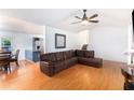 Open-concept living room featuring hardwood floors, a cozy leather sectional, and stairs to second floor at 1902 Seals Rd, Dallas, GA 30157