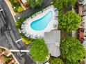 Aerial view of a community swimming pool with plenty of lounge chairs and lush greenery around the edge at 2305 Limehurst Ne Dr # 21, Atlanta, GA 30319