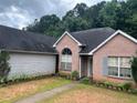 Brick home with a well-kept lawn and an inviting entrance, surrounded by lush greenery, creating a serene setting at 7513 Sugarcreek Dr, Riverdale, GA 30296