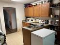 Functional kitchen featuring wooden cabinets, laminate countertops and flooring, and essential appliances for meal preparation at 7513 Sugarcreek Dr, Riverdale, GA 30296