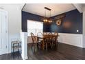 Dining room with dark blue walls, wainscoting, modern light fixture and seating for six at 137 Prominence Ct, Canton, GA 30114
