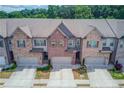 Overhead view of brick townhomes with attached garages and landscaping in a suburban neighborhood at 2005 Hamilton Creek Pkwy, Dacula, GA 30019