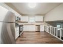 Bright eat-in kitchen features stainless steel appliances, granite counters, white cabinets and vinyl floors at 2233 Cherokee Valley Dr, Lithonia, GA 30058