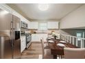 Bright kitchen features stainless steel appliances, white cabinets and a charming dining table at 2233 Cherokee Valley Dr, Lithonia, GA 30058