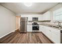 Updated eat-in kitchen features stainless steel appliances, granite counters, white cabinets and vinyl floors at 2233 Cherokee Valley Dr, Lithonia, GA 30058