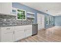 Modern kitchen features white cabinets, granite countertops, stainless steel appliances and stylish backsplash at 4753 Klondike Cv, Lithonia, GA 30038