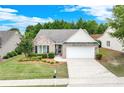 Well-maintained home featuring a brick facade, manicured lawn, mature landscaping, and a two-car garage at 936 Village View Cir, Loganville, GA 30052