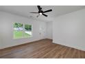 Bright living room featuring wood floors, ceiling fan, and view of the landscaped front yard at 1534 River Rock Trce, Woodstock, GA 30188