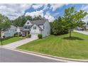 A Beautiful two-story home showcasing its well-maintained lawn and a long driveway at 3906 Elm Trace Ct, Loganville, GA 30052