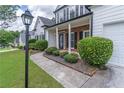 The inviting front entrance features a brick porch and meticulously landscaped surroundings at 3906 Elm Trace Ct, Loganville, GA 30052
