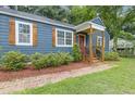 Close-up of the home's entry with updated landscaping, shutters, and covered porch at 2728 Mcafee Rd, Decatur, GA 30032