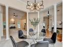 Dining area with a modern glass table, statement chandelier, and open-concept layout at 1635 Lake Heights Cir, Dacula, GA 30019